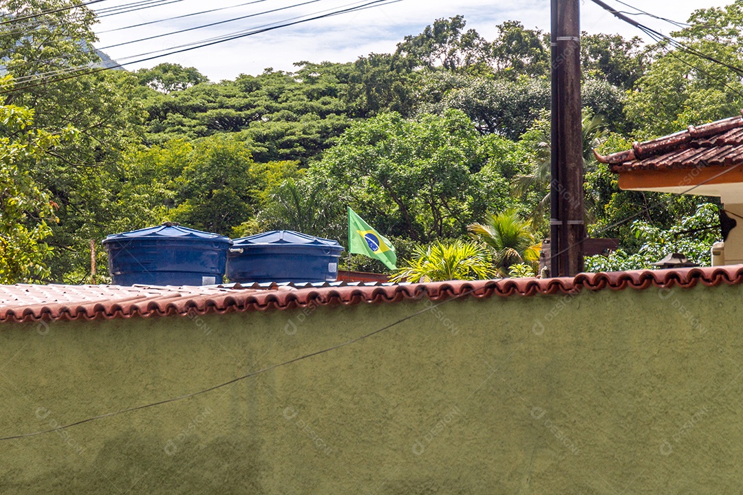 Bandeira brasileira voando no quintal de uma casa no Rio de Janeiro, Brasil.