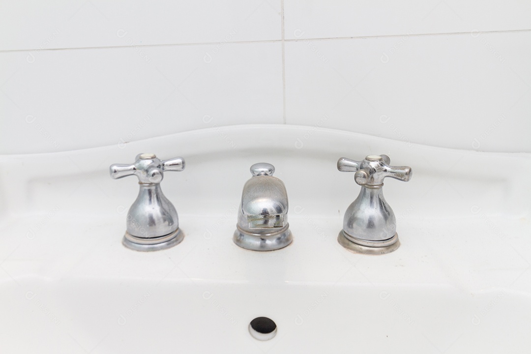 torneira de ferro cinza, em uma pia branca no Rio de Janeiro, Brasil.