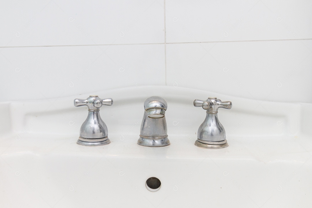 torneira de ferro cinza, em uma pia branca no Rio de Janeiro, Brasil.