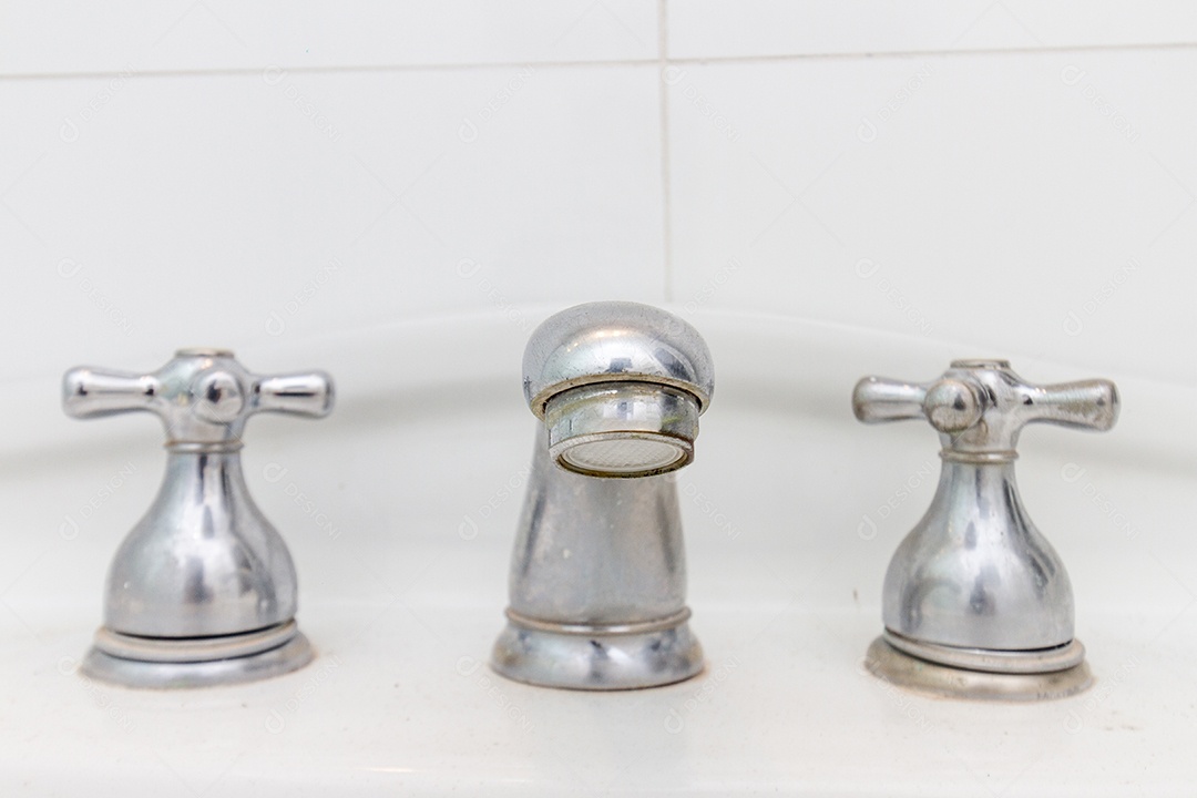 torneira de ferro cinza, em uma pia branca no Rio de Janeiro, Brasil.