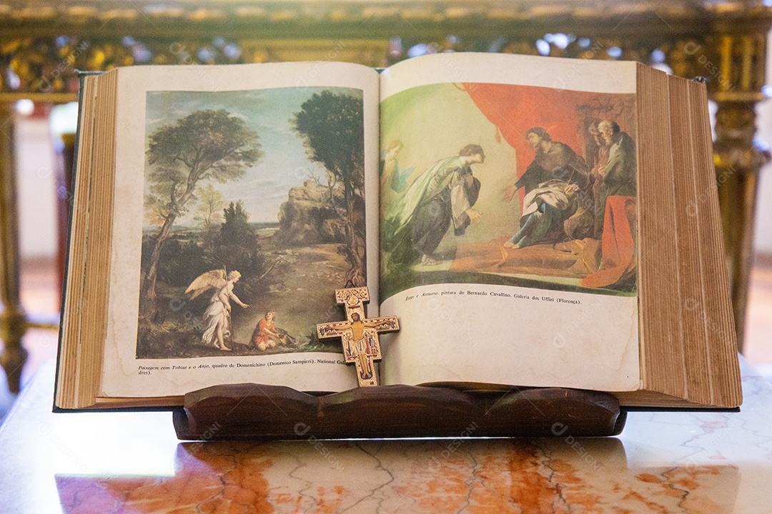 Livro com imagens católicas e uma cruz no centro, dentro