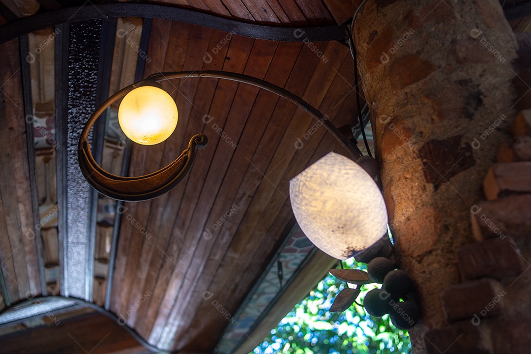 lâmpada vintage em uma parede de pedra com teto de madeira no Rio de Janeiro