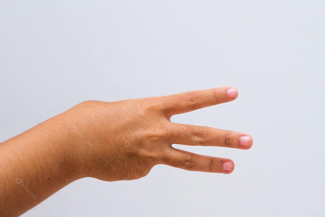 criança fazendo sinal número em um fundo branco no Rio de Janeiro.