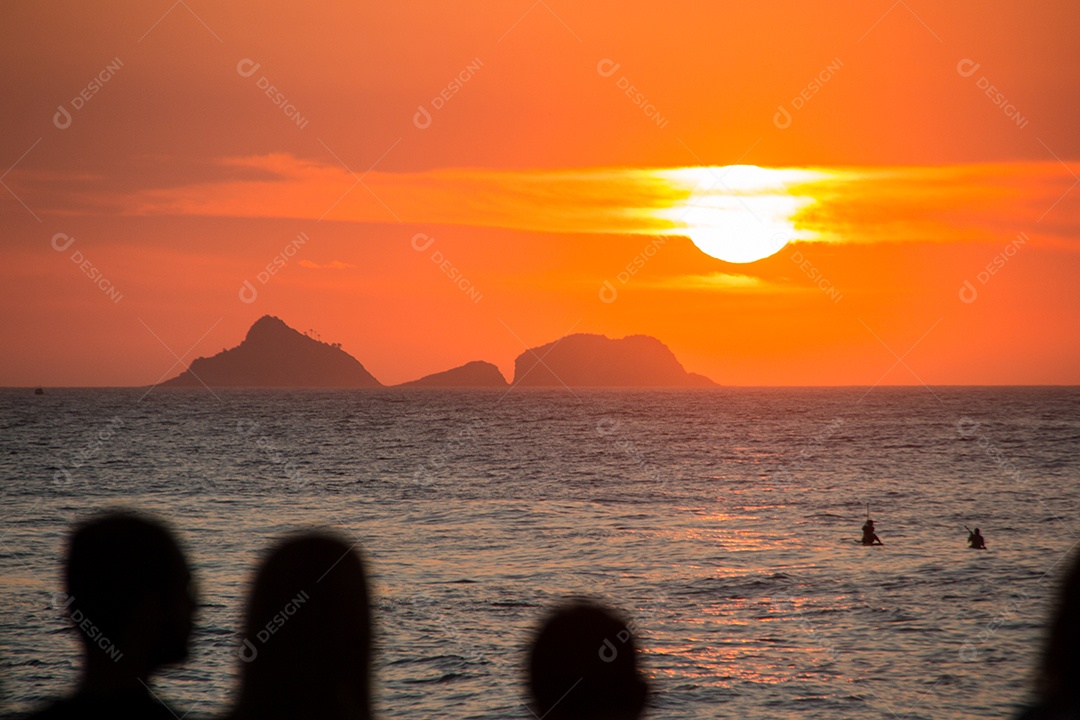 silhouette of people watching the sunset at arpoador beach in rio de janeiro, brazil.