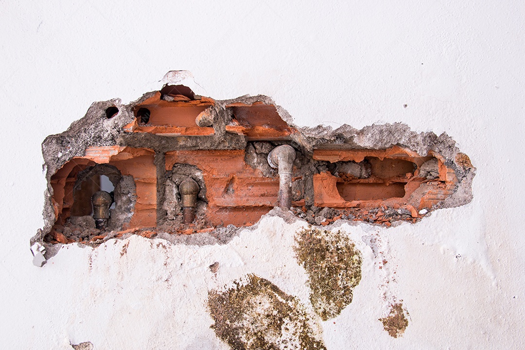 parede branca quebrada com tijolos expostos em um prédio no Rio de Janeiro, Brasil.