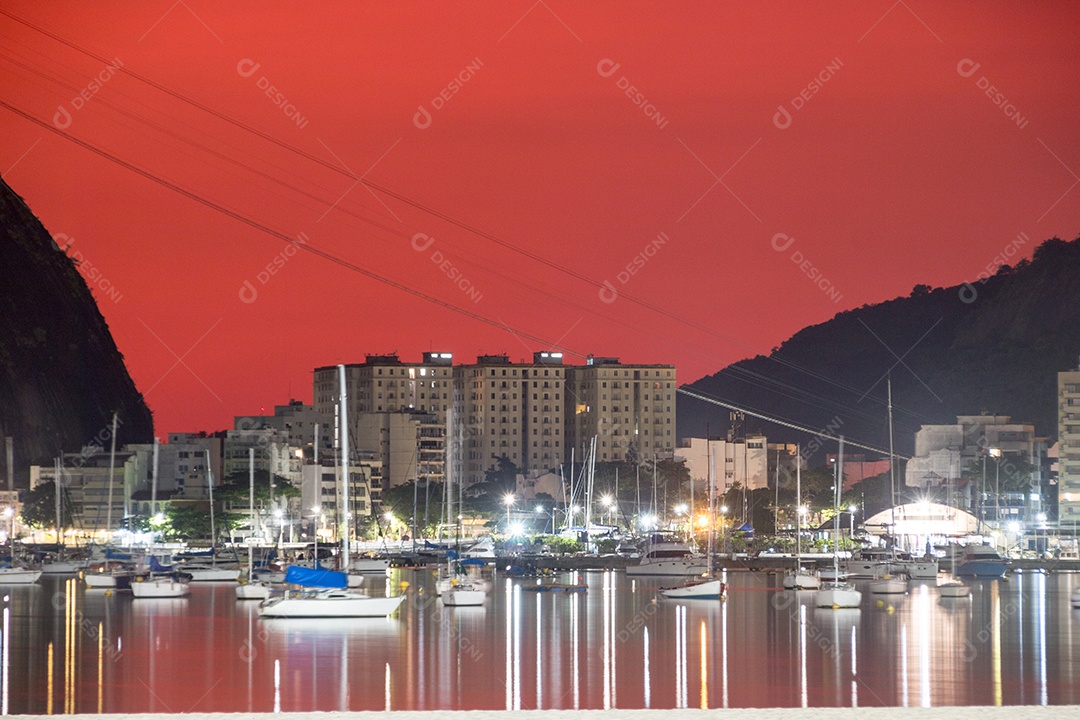 céu com a cor vermelha, sob a influência das cinzas do vulcão de Tonga na enseada de Botafogo no Rio de Janeiro.