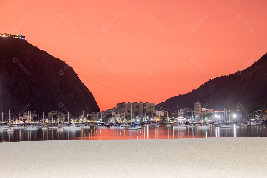 céu com a cor vermelha, sob a influência das cinzas do vulcão de Tonga na enseada de Botafogo no Rio de Janeiro.