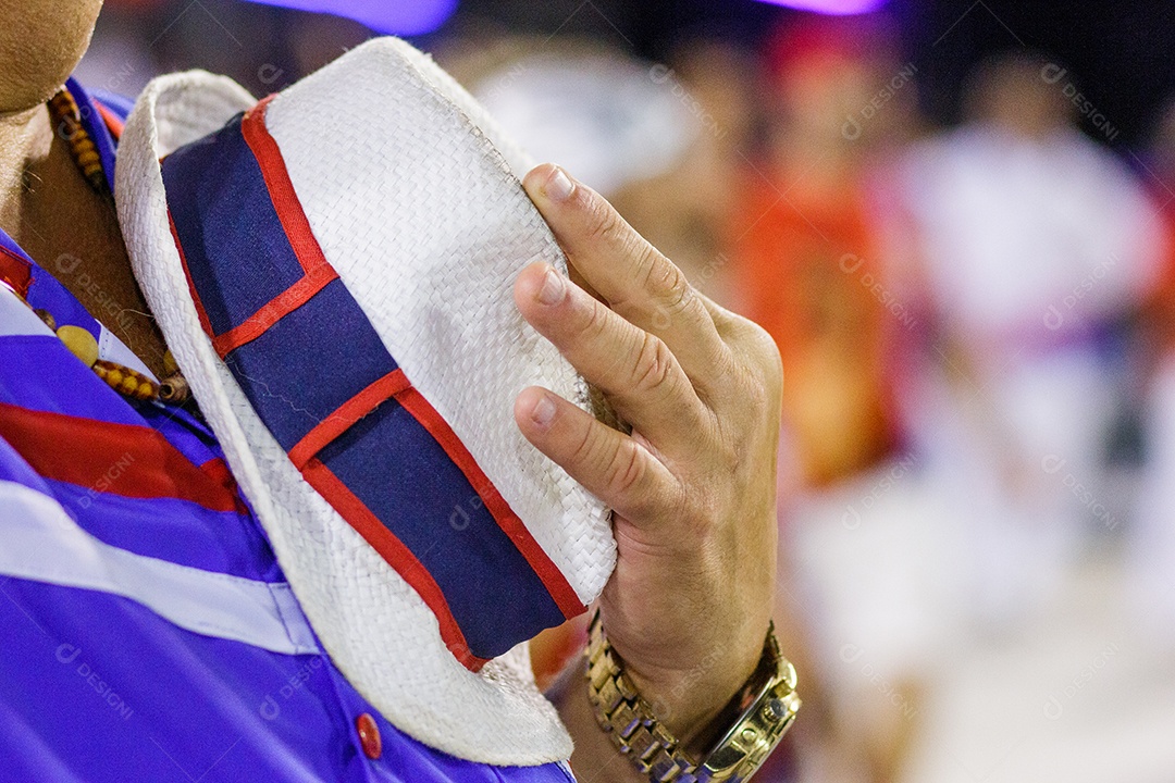 homem segurando um chapéu na altura do peito no Rio de Janeiro.