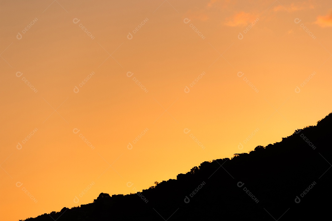 silhueta de uma montanha com um lindo céu laranja por do sol no Rio de Janeiro.