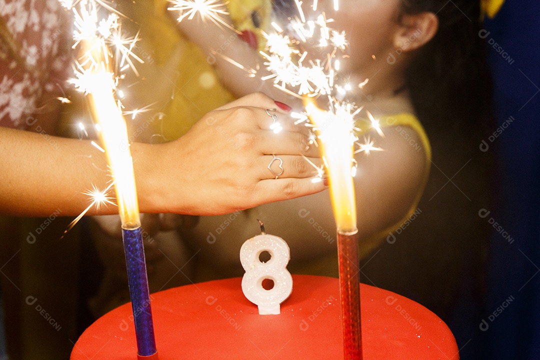 mão em uma vela de aniversário de 8 anos