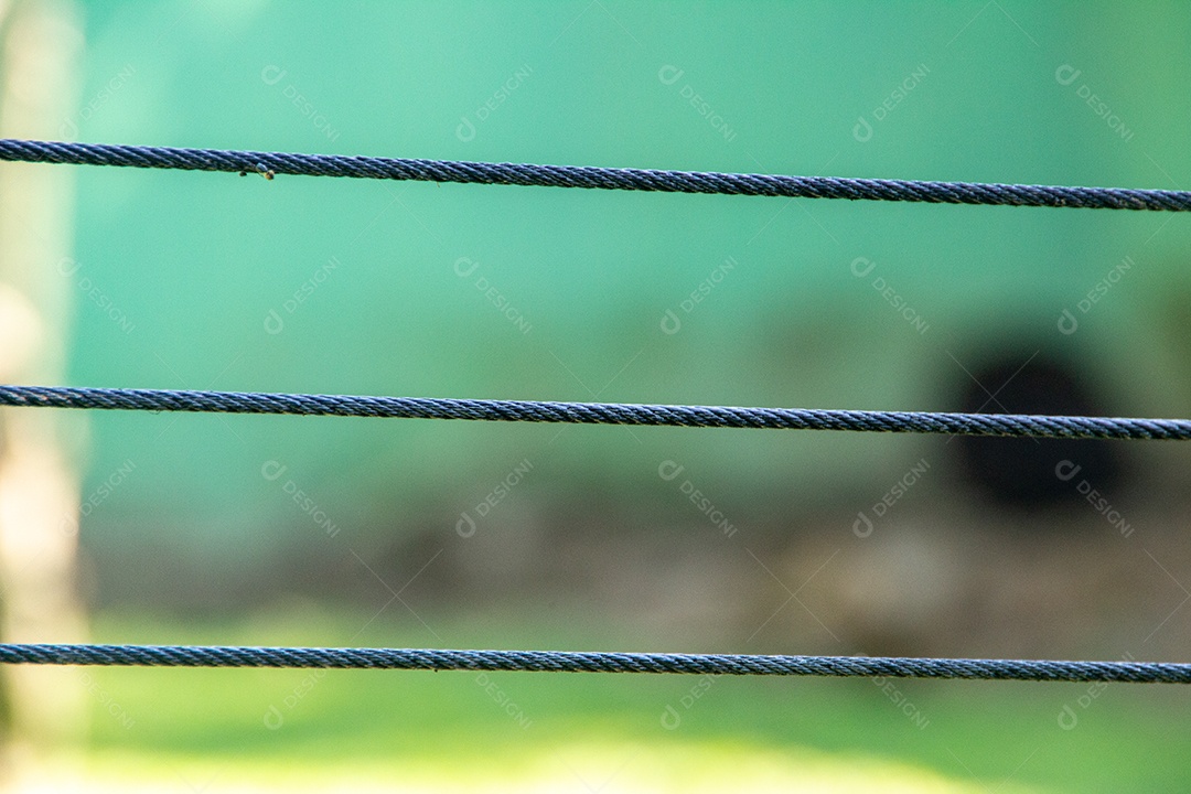 Três fios de cabo de aço com fundo verde no Brasil.