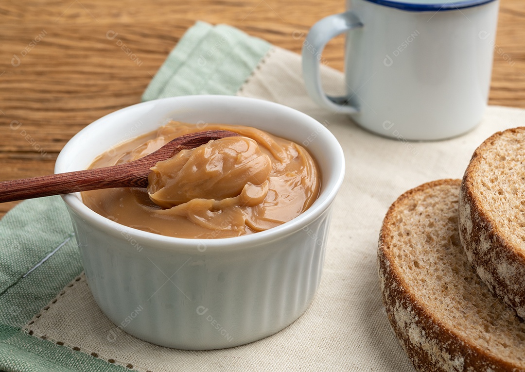Doce de leite, doce de leite cremoso tradicional brasileiro sobre mesa de madeira.