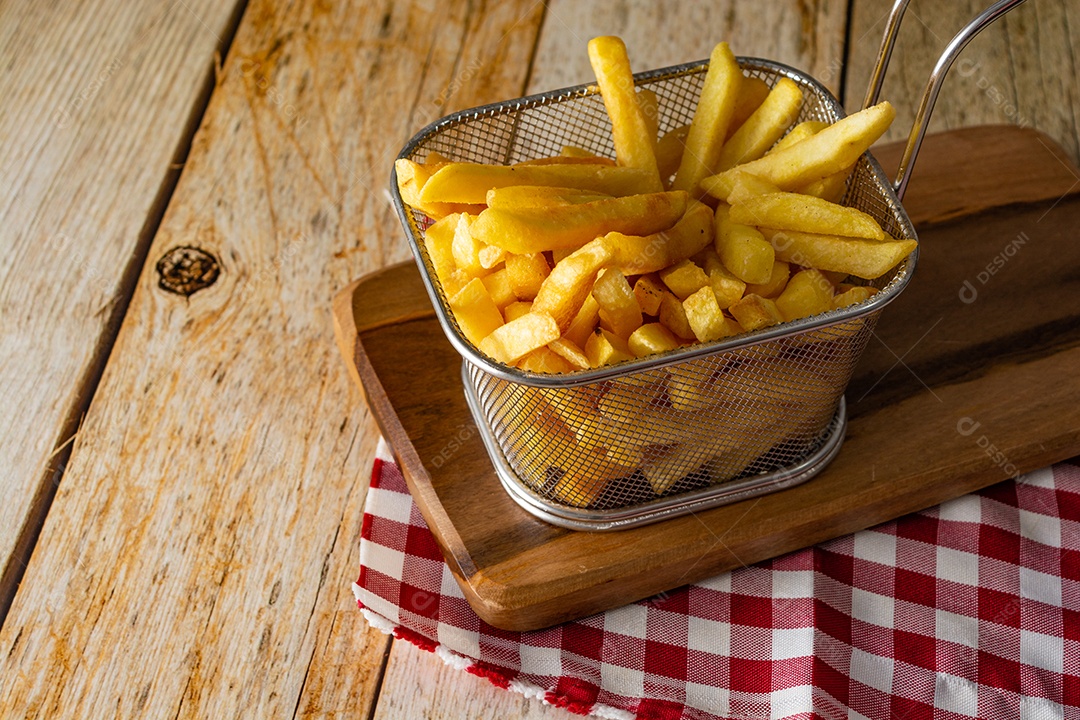cesta cheia de batatas fritas na mesa de madeira rústica