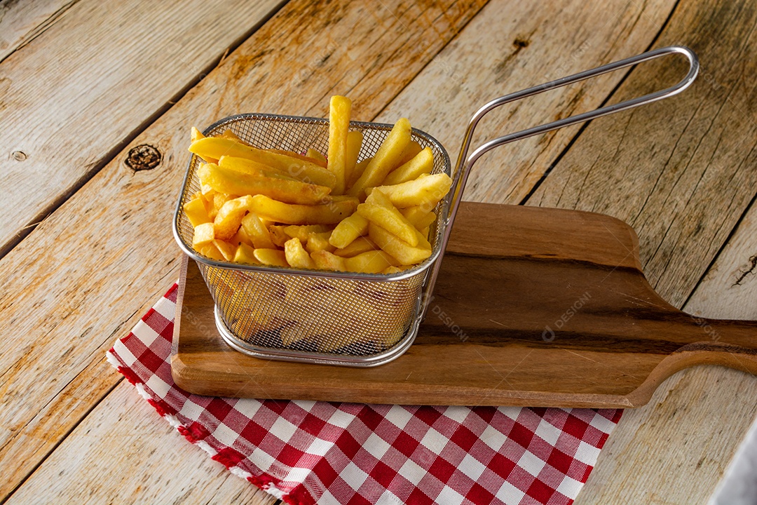 cesta cheia de batatas fritas na mesa de madeira rústica