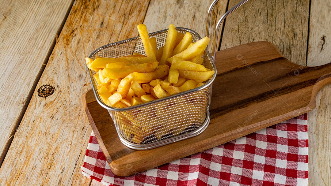 cesta cheia de batatas fritas na mesa de madeira rústica