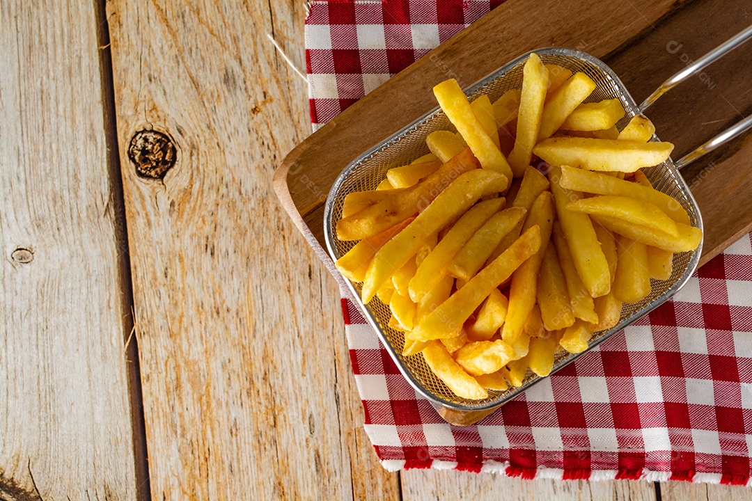 cesta cheia de batatas fritas na mesa de madeira rústica