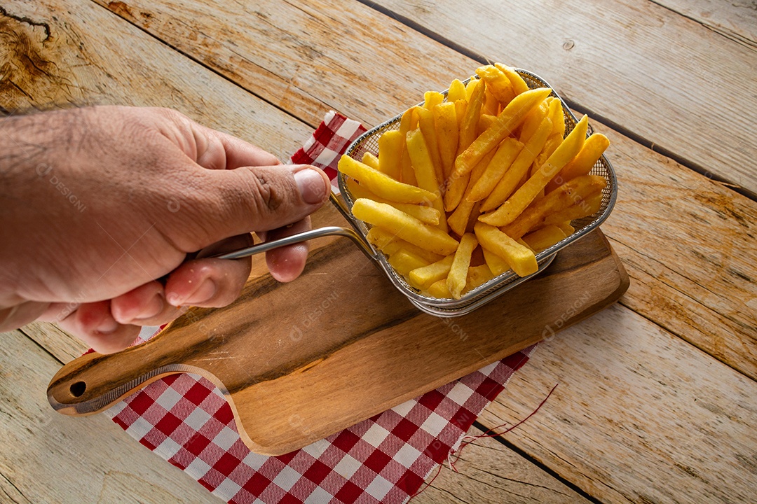 cesta cheia de batatas fritas na mesa de madeira rústica