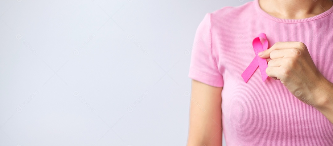 Mês de conscientização do câncer de mama de outubro rosa, mão de mulher segura rosa