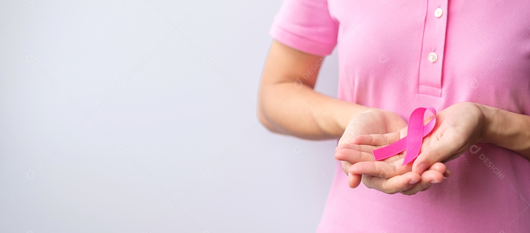 Mês de conscientização do câncer de mama de outubro rosa, mão de mulher segura rosa