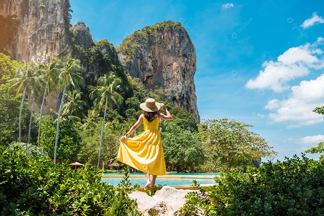 Turista de mulher de vestido amarelo e chapéu viajando na praia de Railay, Krabi, Tailândia. férias, viagens, verão, Wanderlust e conceito de férias