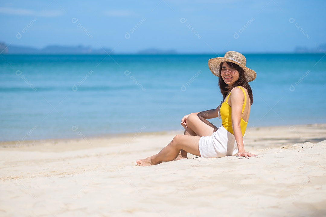 Turista de mulher de maiô amarelo e chapéu, feliz viajante tomando sol na praia do paraíso nas ilhas. destino, desejo de viajar, Ásia Travel, verão tropical, férias e conceito de férias