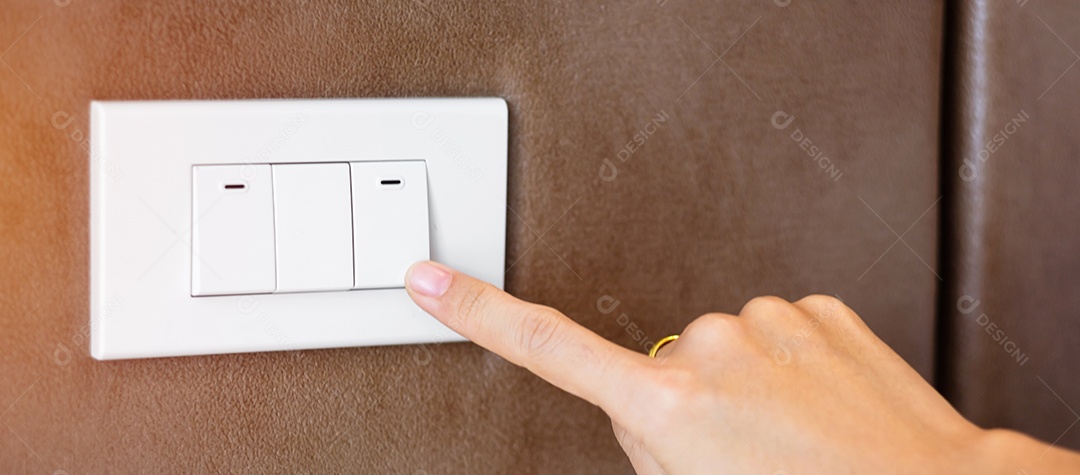 Dedo ligar ou desligar o interruptor de luz na parede em casa. Conceitos de economia de energia, energia, eletricidade e estilo de vida