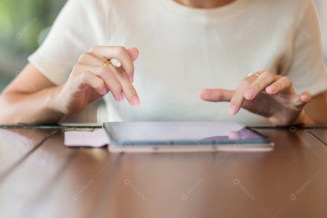 Mulher usando tablet para mensagens sms, mão segurando lápis digitando celular touchscreen no café ou escritório moderno. estilo de vida, tecnologia, mídia social e conceito de rede