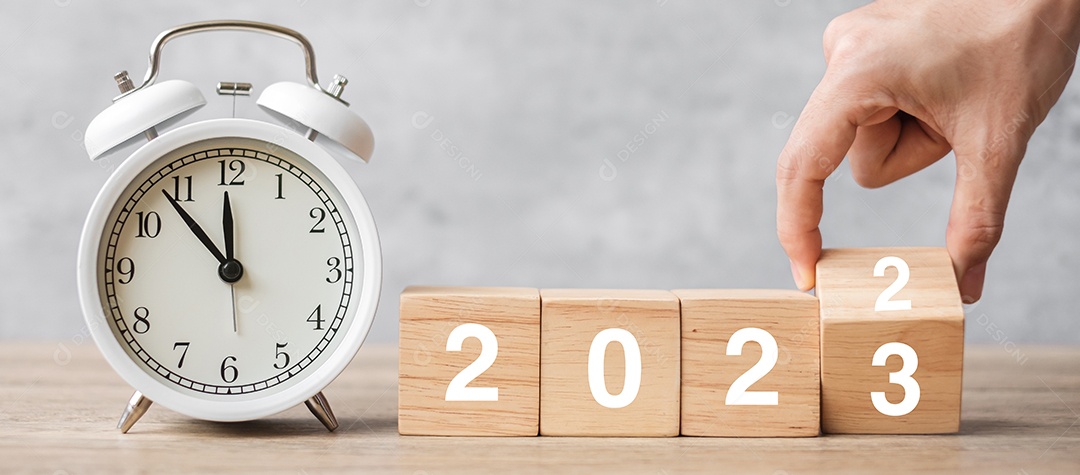 Feliz Ano Novo com despertador vintage e mudança manual de 2022 para o bloco de 2023. Natal, novo começo, resolução, contagem regressiva, metas, plano, ação e conceito de motivação