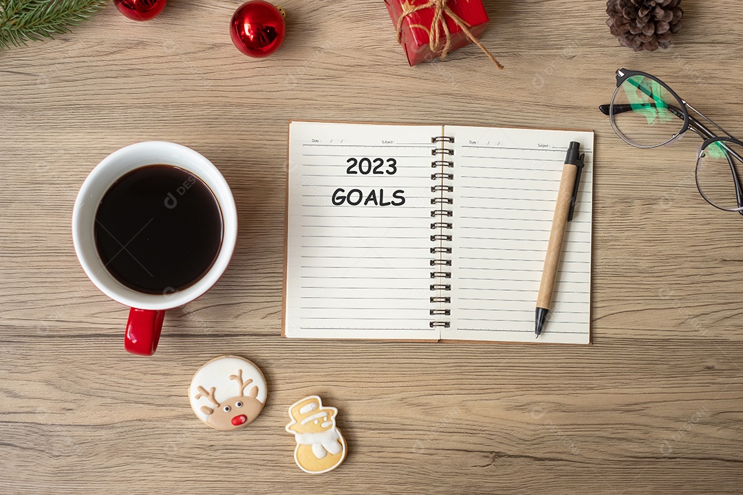 2023 GOAL com notebook, xícara de café preto, biscoitos de Natal e caneta na mesa de madeira. Natal, feliz ano novo, resolução, lista de tarefas, conceito de estratégia e plano