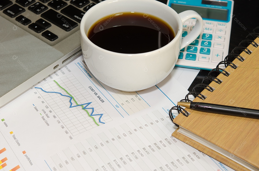 Documentos de negócios computador e caneta na mesa.