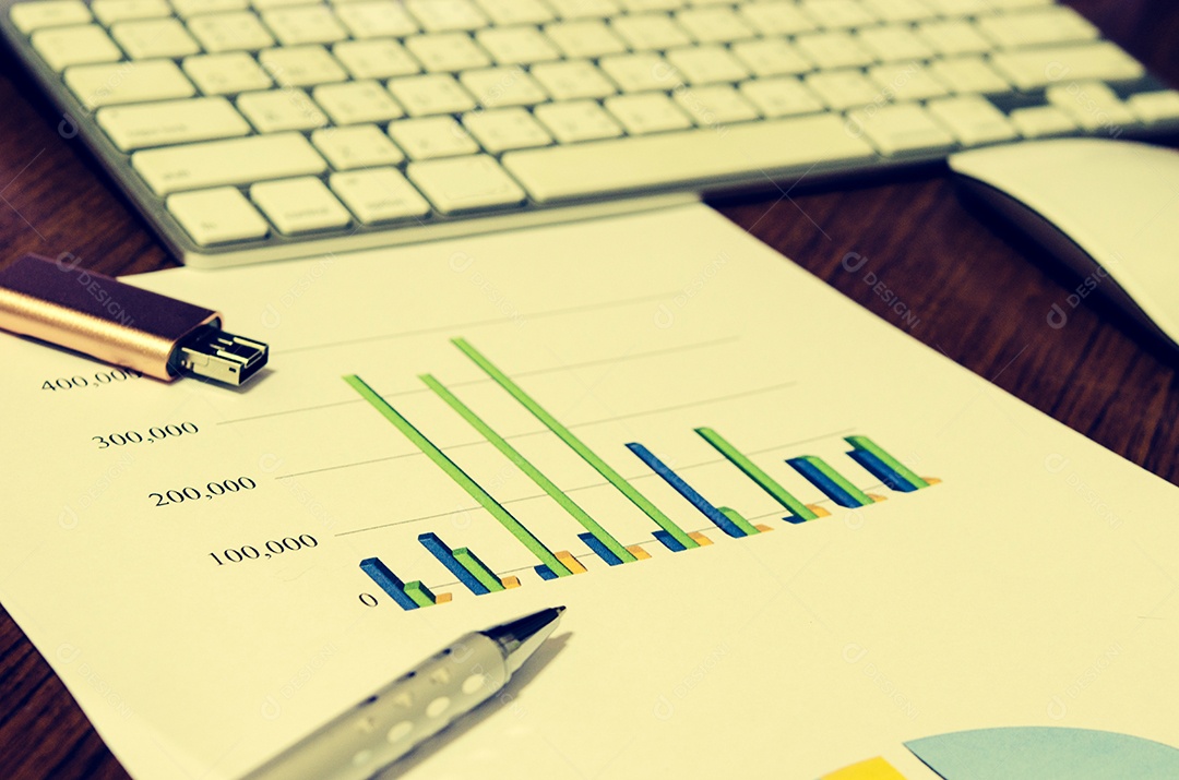 Laptop e papel de relatório na mesa de madeira de escritório vintage.