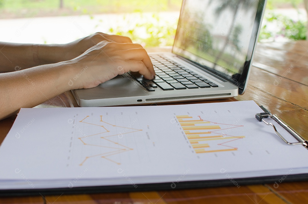 Mulher trabalhando em dados financeiros com computador.