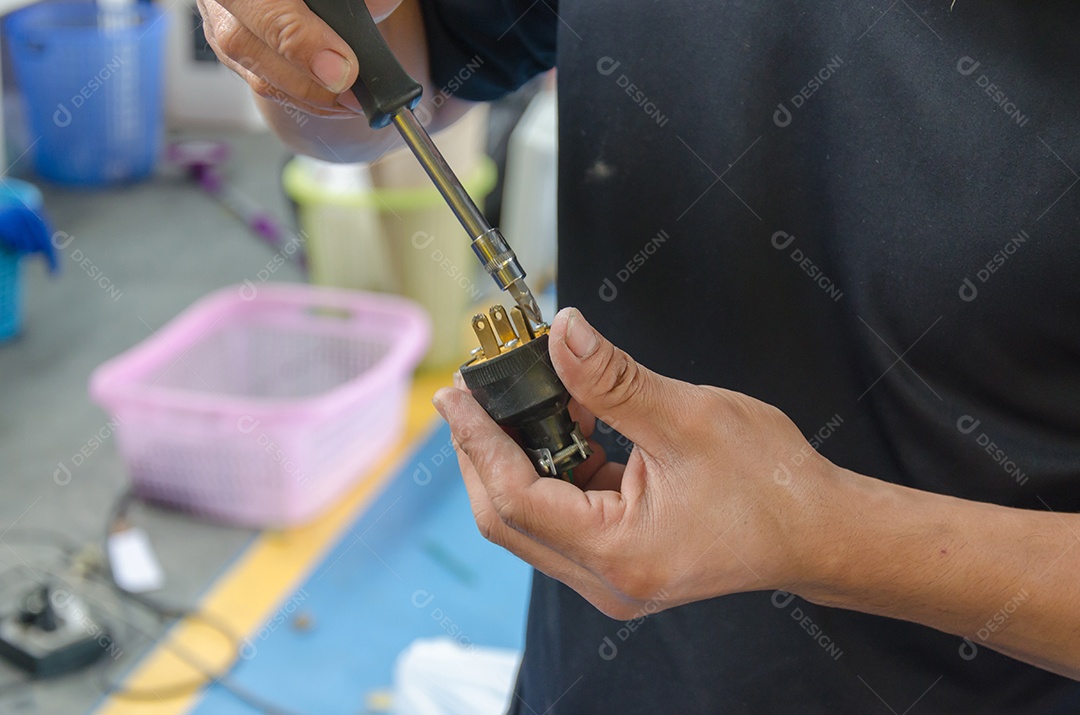 Homens reparando um soquete com uma chave de fenda.