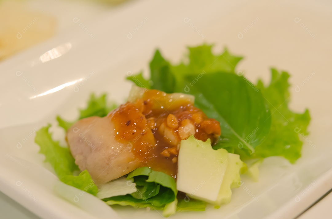 Comida vietnamita servida com molhos e legumes.