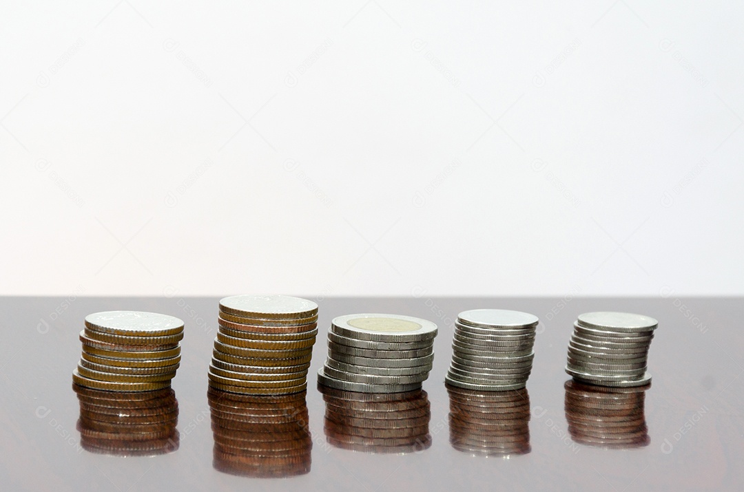 Moedas empilhadas sobre a mesa.