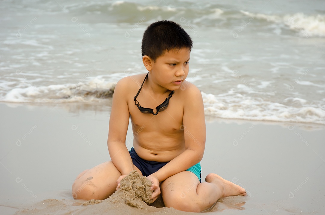 Garota brincando na areia da praia.