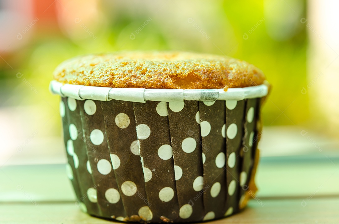 O cupcake colocado no chão de madeira.