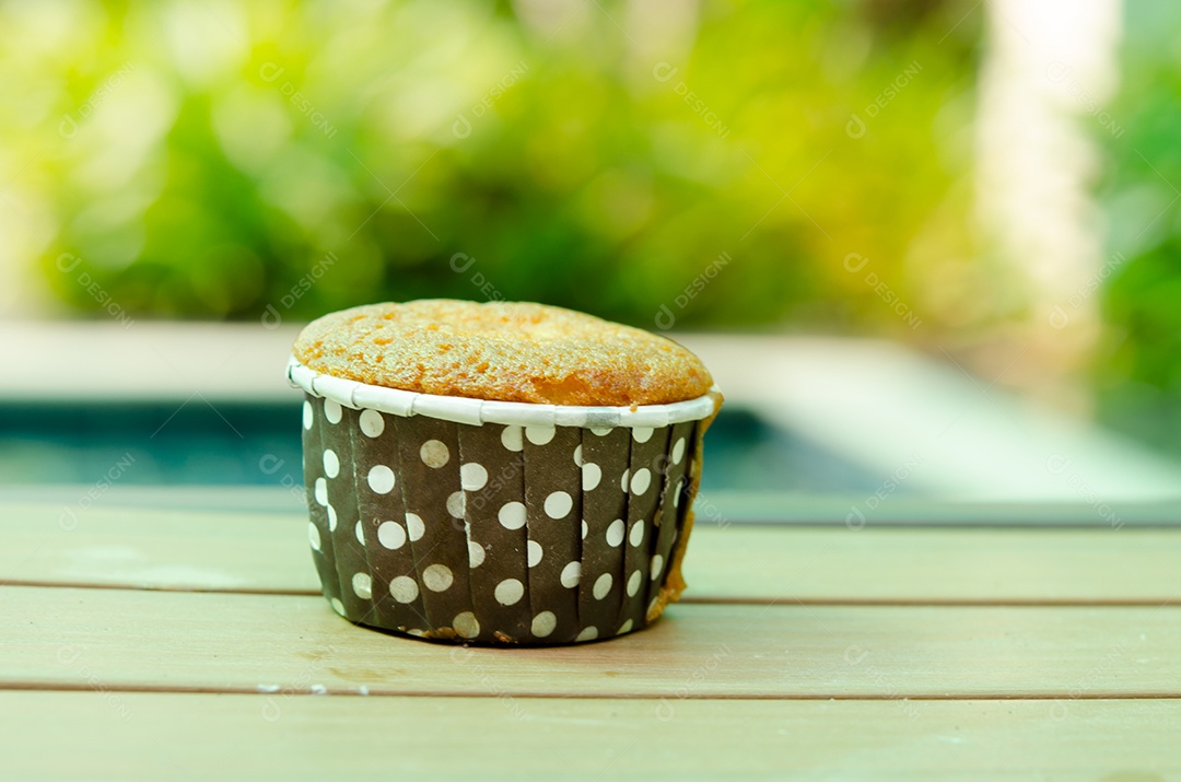 O cupcake colocado no chão de madeira.
