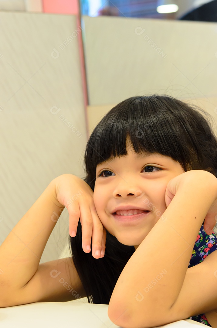 A menina senta-se sorrindo.