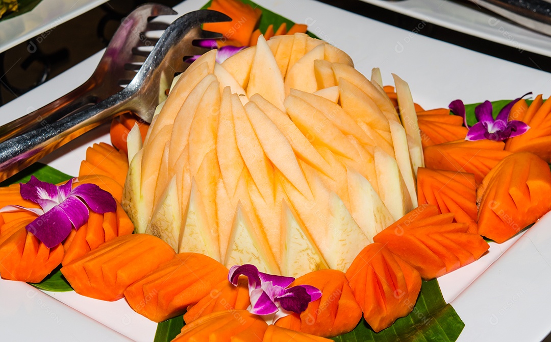 Melão e mamão são colocados no prato.