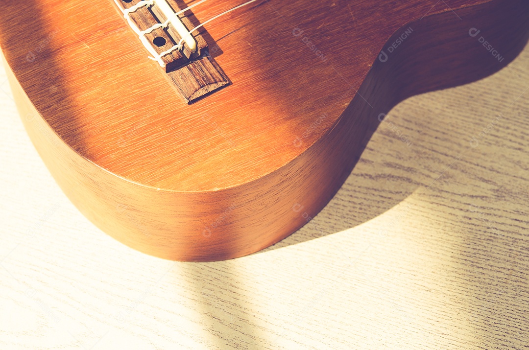 Ukulele vintage em fundo de madeira.