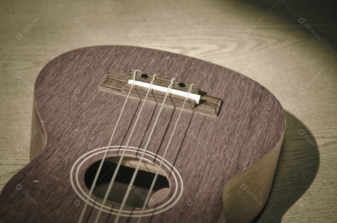 Ukulele vintage em fundo de madeira.