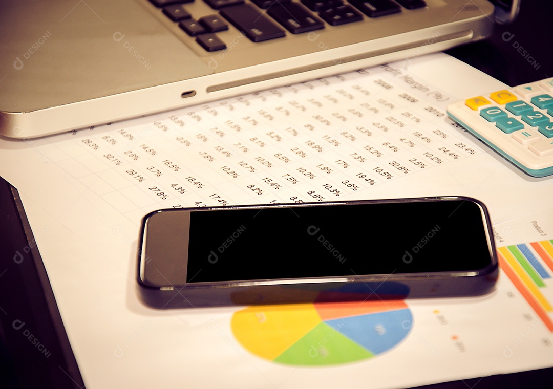 Gráfico de negócios com telefone inteligente na mesa.