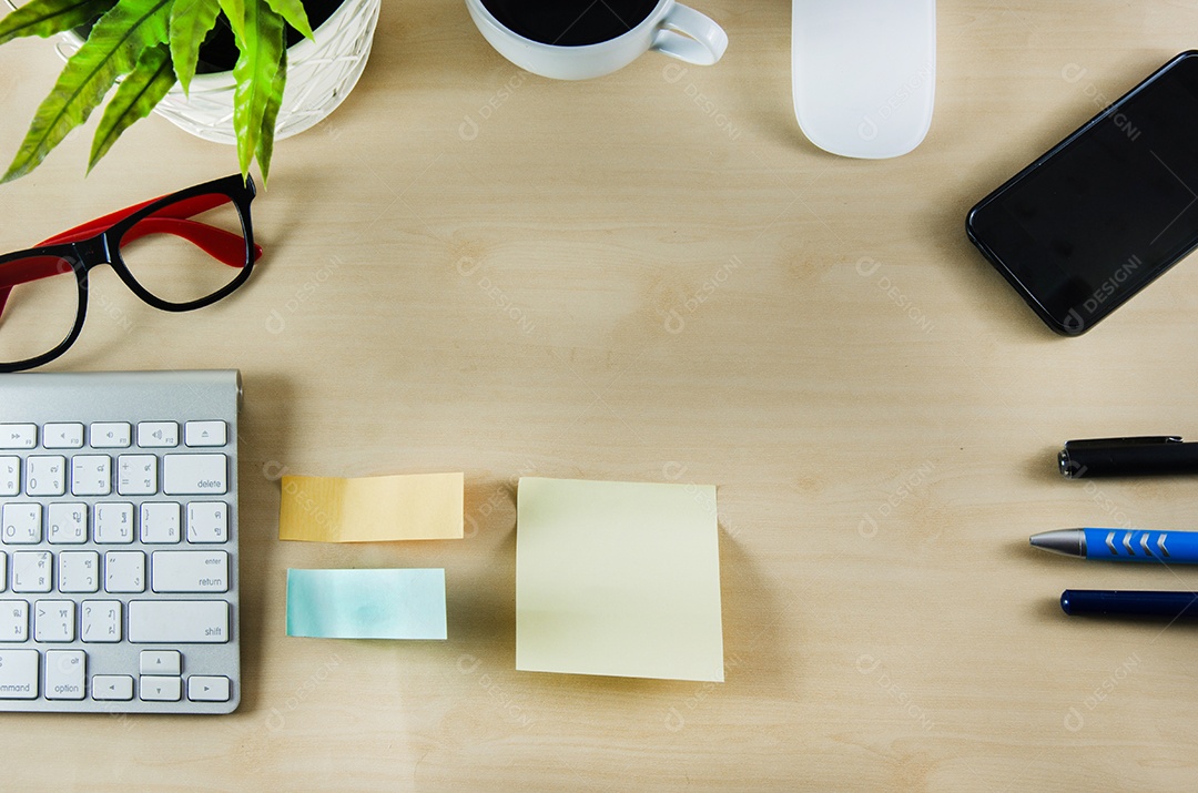 Material de escritório e xícara de café na mesa de madeira.