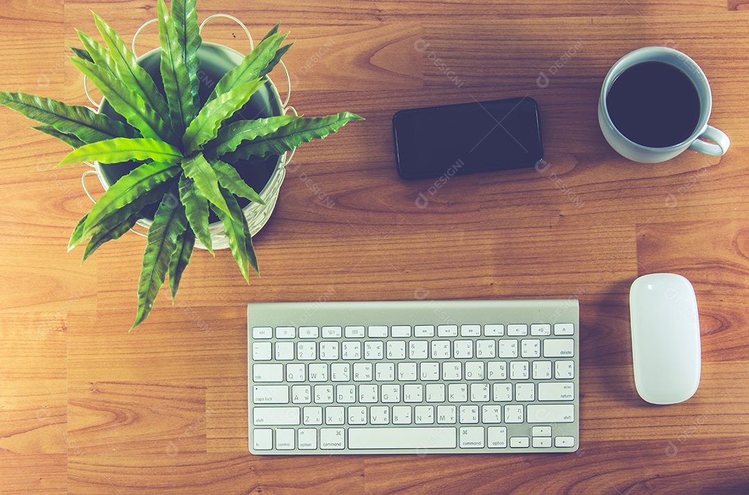 Mesa de escritório com bloco de notas, computador e xícara de café.