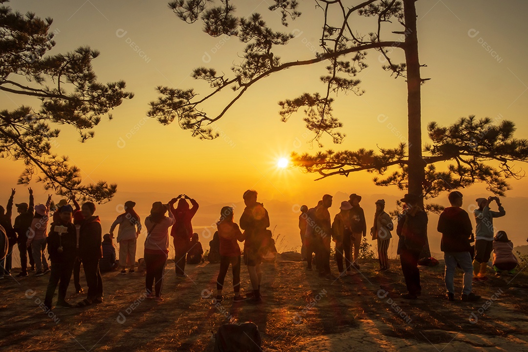 Bela silhueta de caminhante aprecia a névoa e o nascer do sol em Nok Aen