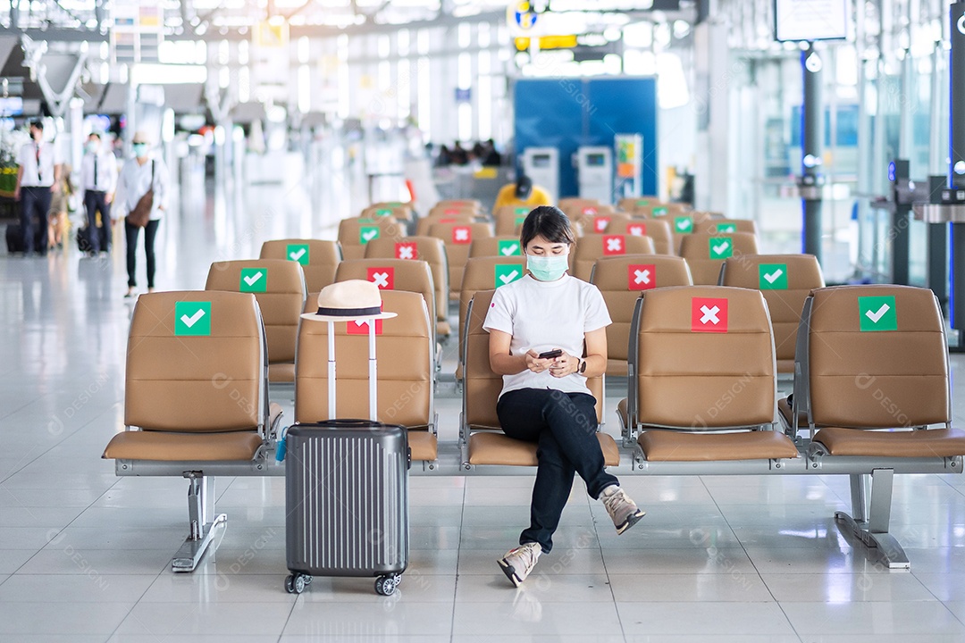 Jovem mulher usando máscara facial e usando smartphone
