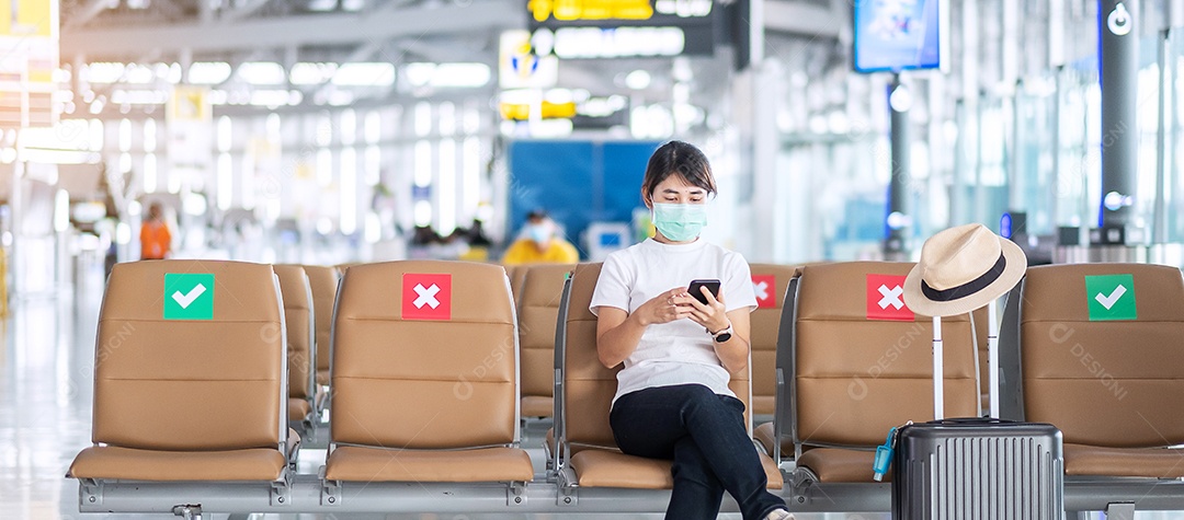 Jovem mulher usando máscara facial e usando smartphone
