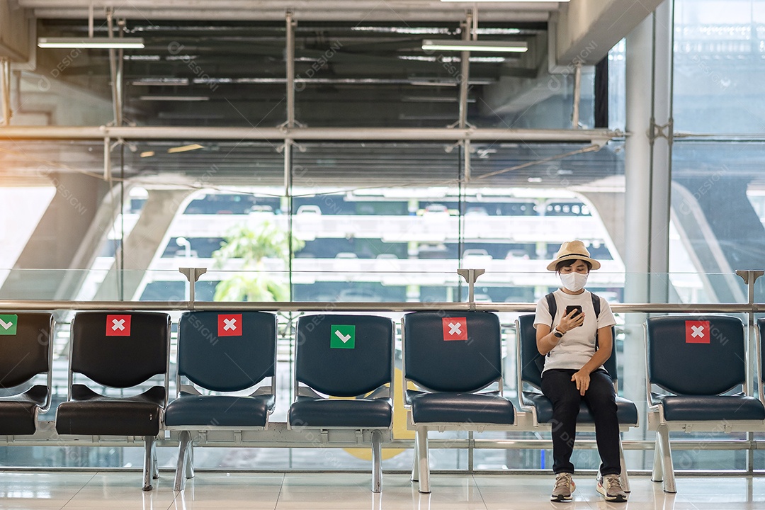 Jovem mulher usando máscara facial e usando smartphone