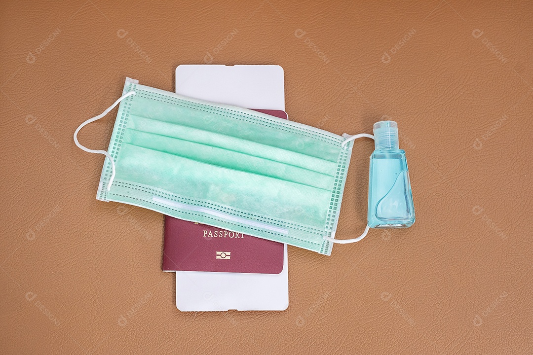Máscara facial médica, desinfetante de gel de álcool e passaporte no fundo da cadeira de couro no aeroporto internacional, proteção contra infecção por doença de coronavírus. Novo Normal e viagens sob conceitos COVID-19